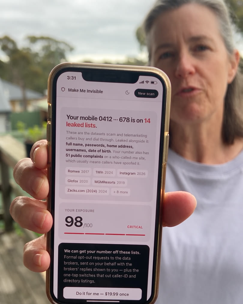 Woman on a back deck holding up a phone showing her Make Me Invisible result